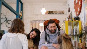 Backpackers cheerfully checking in at a vibrant hostel reception desk.