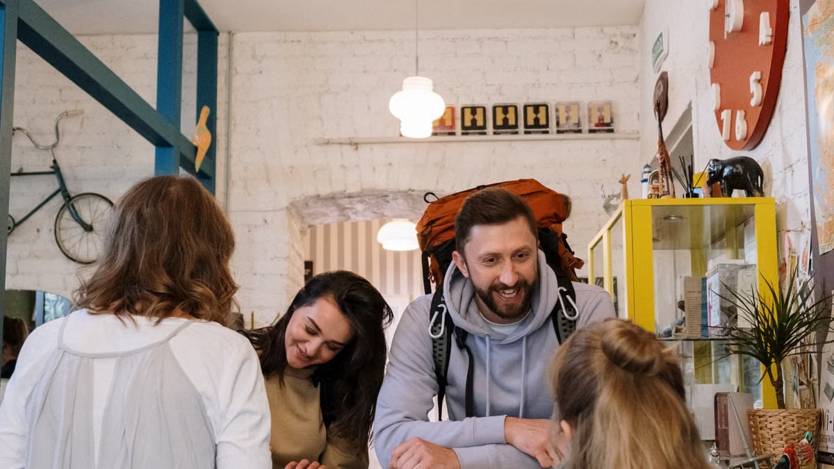 Backpackers cheerfully checking in at a vibrant hostel reception desk.
