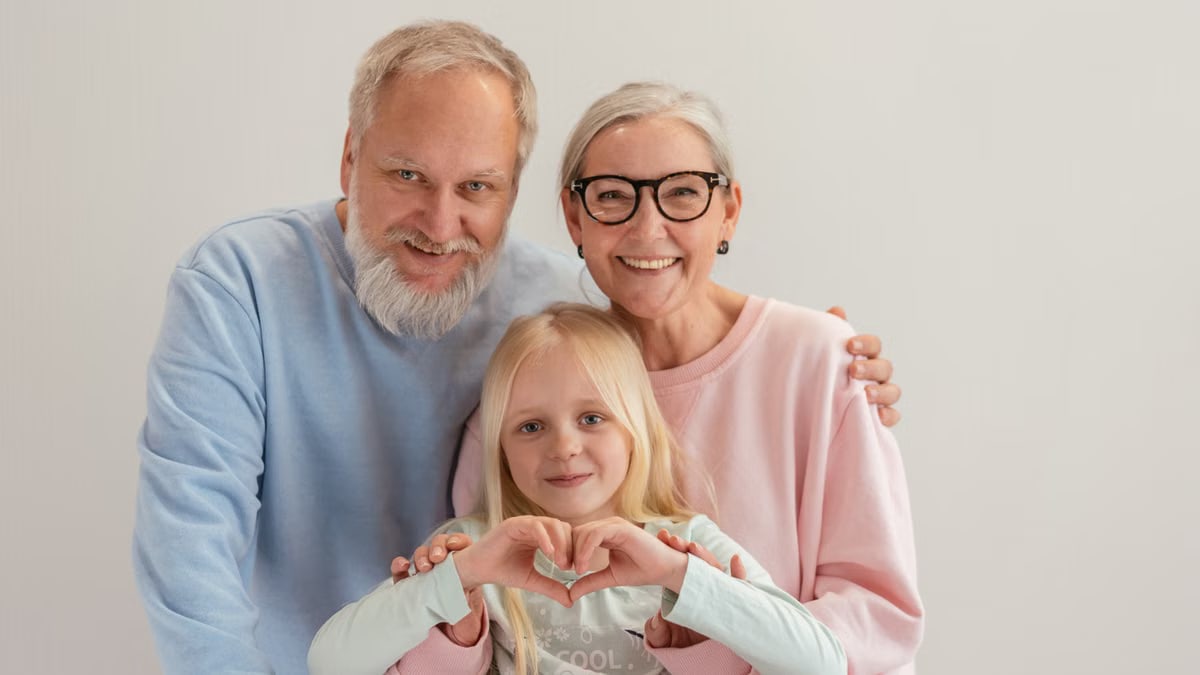 Grandparents and granddaughter share a joyful moment, symbolizing love and family unity indoors.